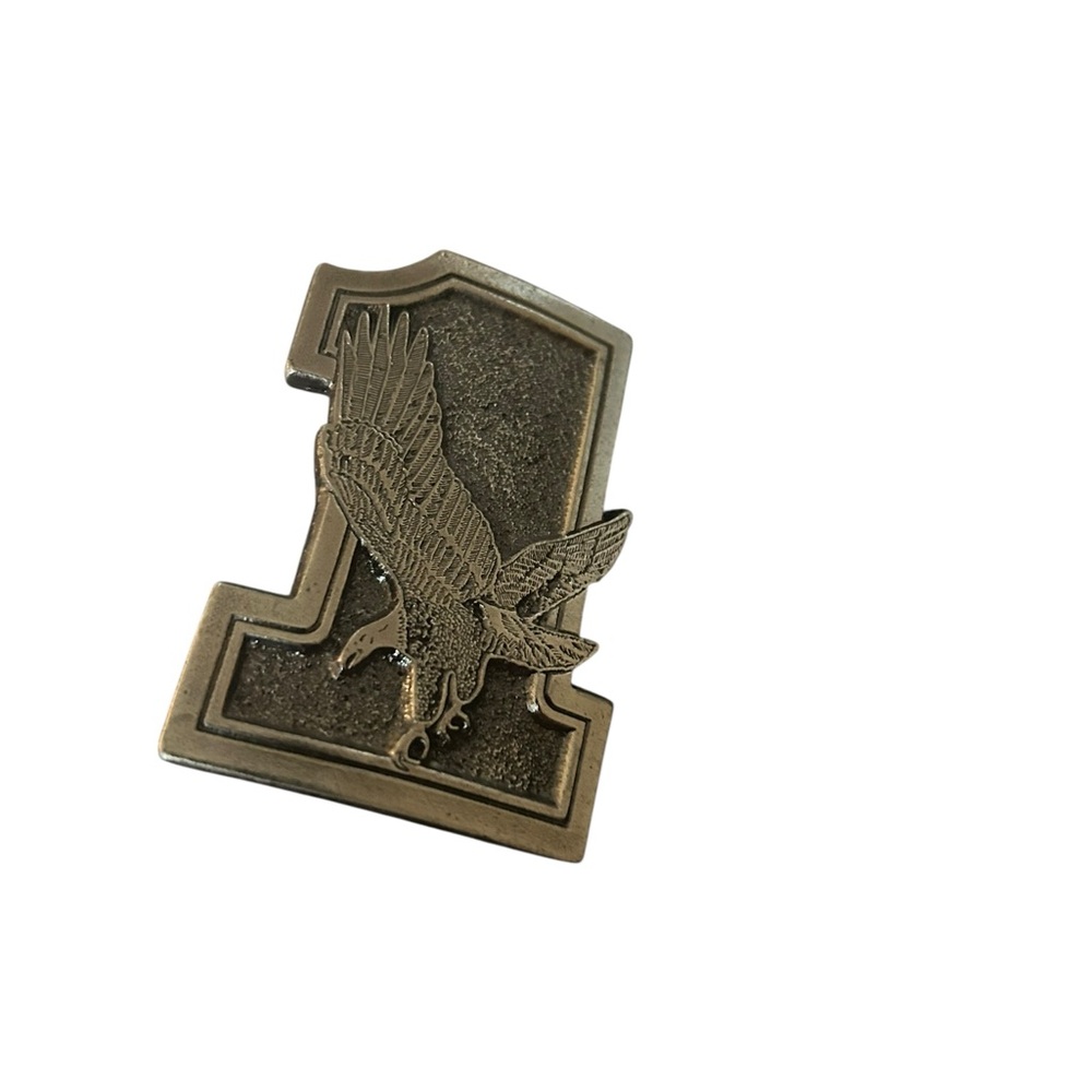 vintage belt buckle featuring an eagle soaring in front of a stylized number one